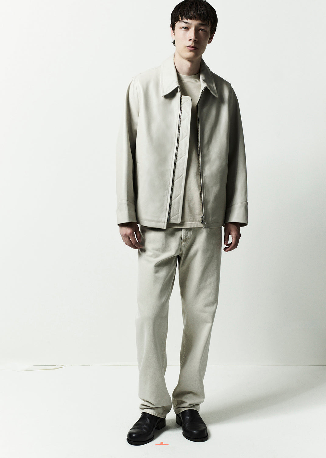 Person wearing a light gray suit on a white background