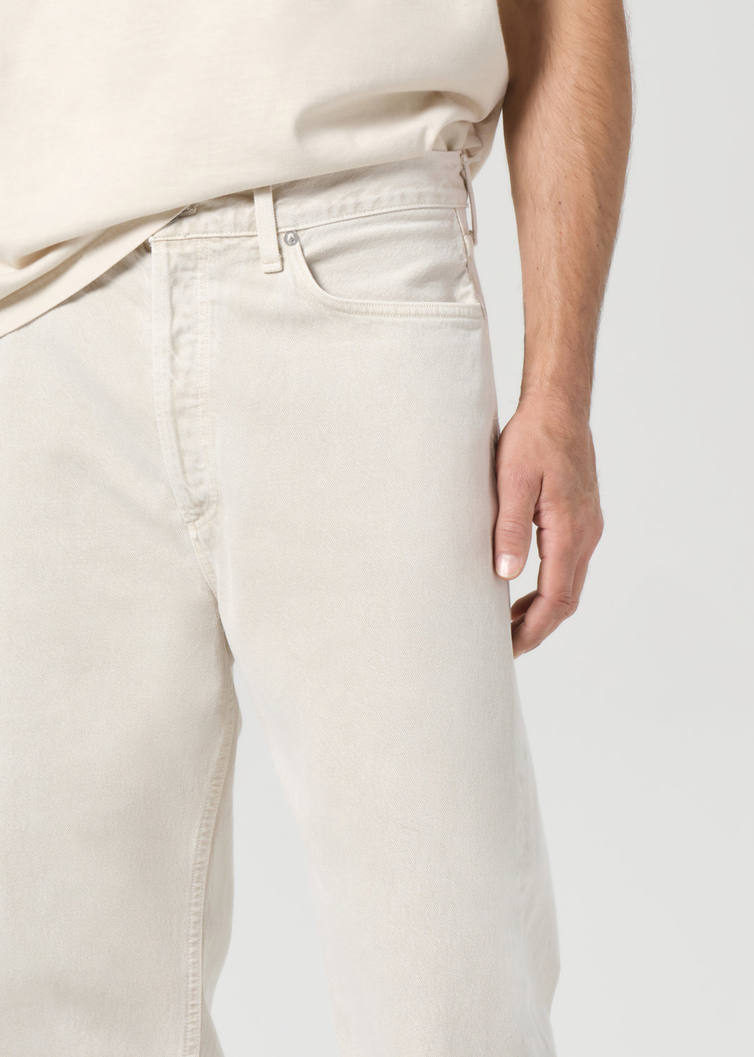 Person wearing light-colored pants on a plain background