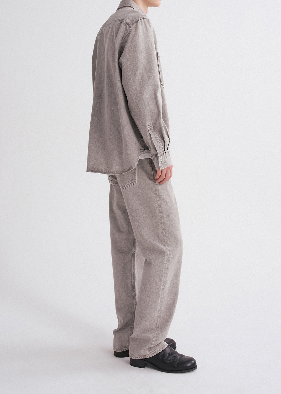 Person wearing a gray outfit on a grey background