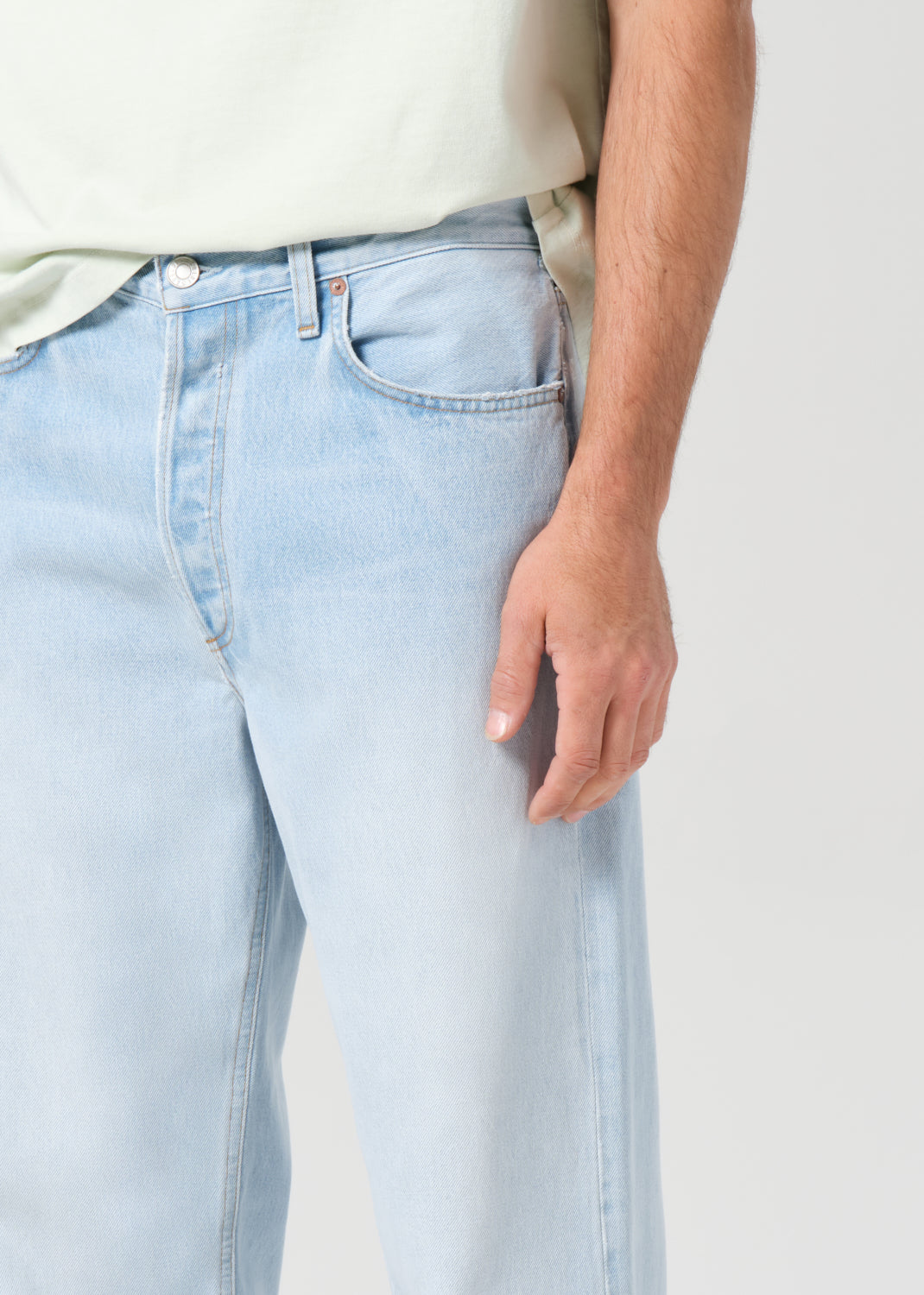 Light blue jeans worn by a person on a plain background