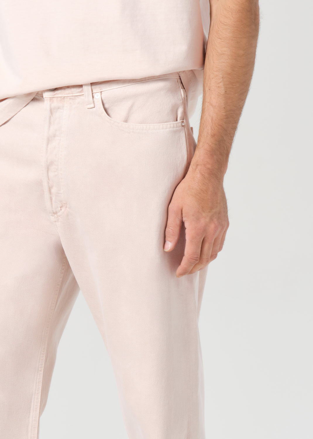 Light pink pants worn by a person on a white background