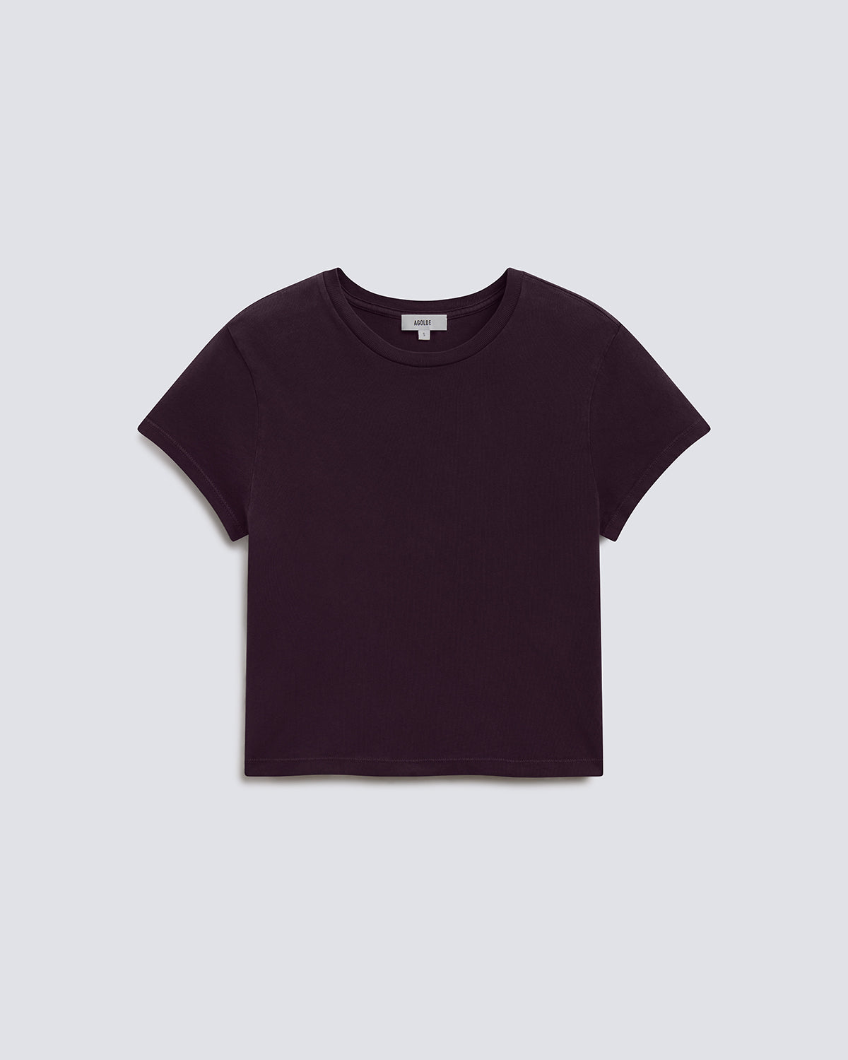 A dark plum purple short-sleeve crop top t-shirt, laid flat against a light gray background.