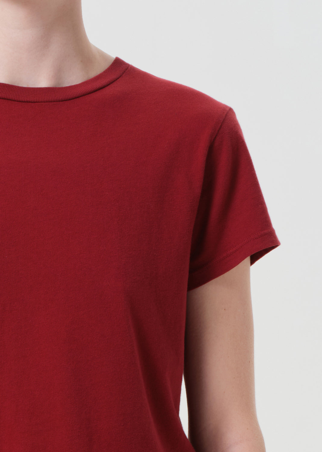 Red t-shirt worn by a person on a plain background