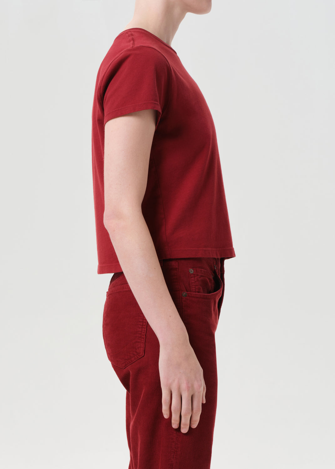 Person wearing a red t-shirt and pants on a white background