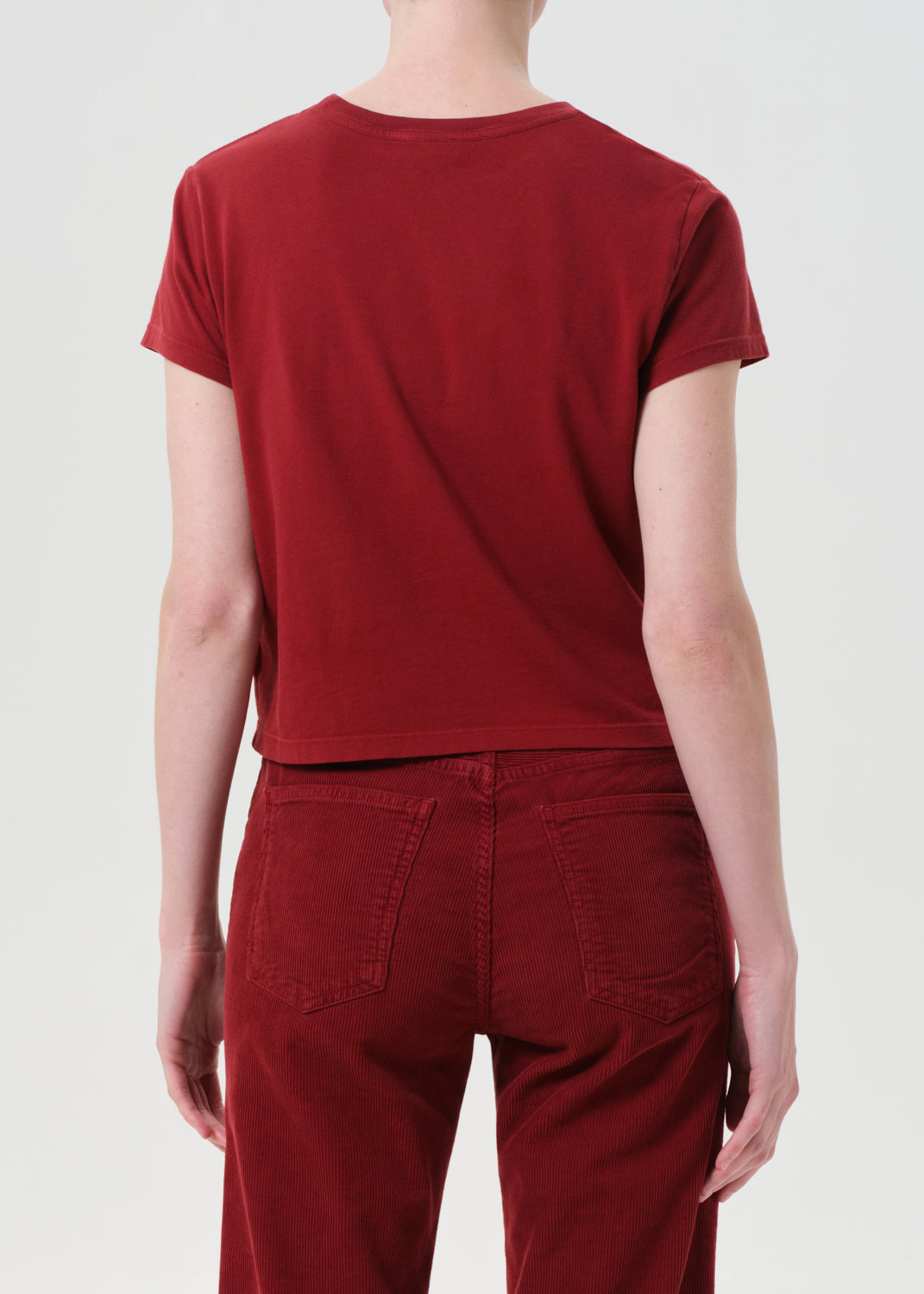 Person wearing a red t-shirt and pants on a white background