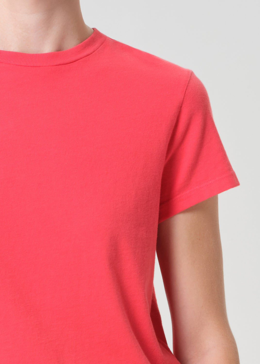 Red t-shirt worn by a person on a light gray background