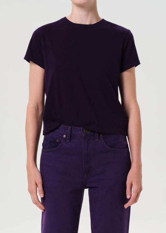 Person wearing a dark purple t-shirt and pants on a white background