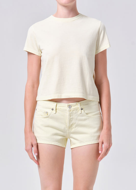Person wearing a light yellow t-shirt and shorts on a plain background
