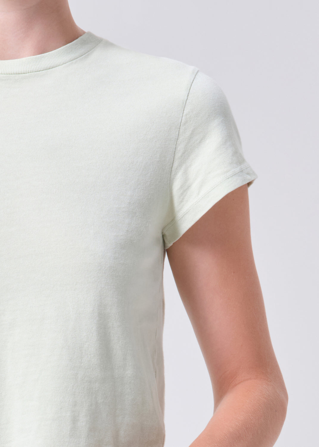 Light green t-shirt worn by a person on a plain background