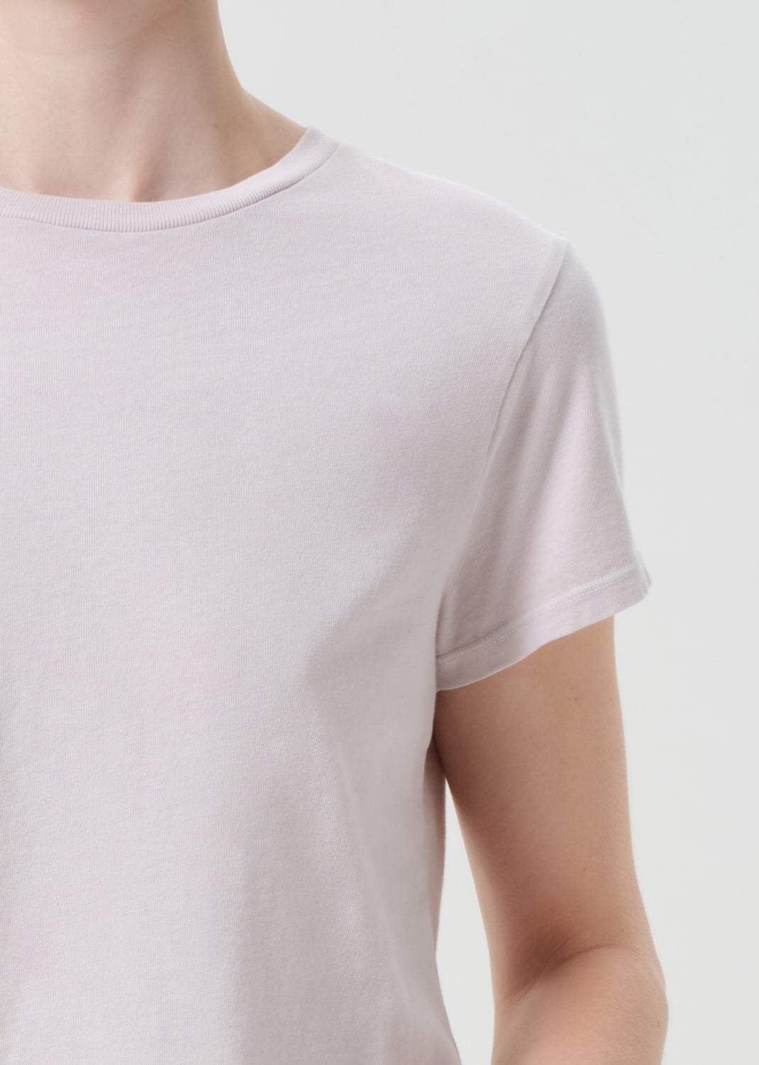 Light purple t-shirt worn by a person on a plain background