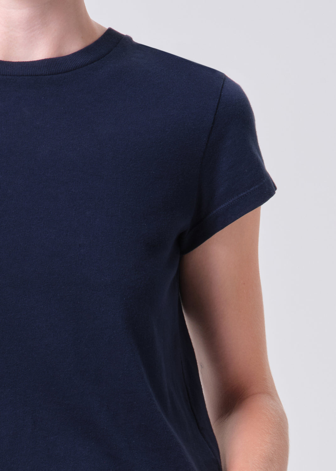 Navy blue t-shirt worn by a person on a light gray background
