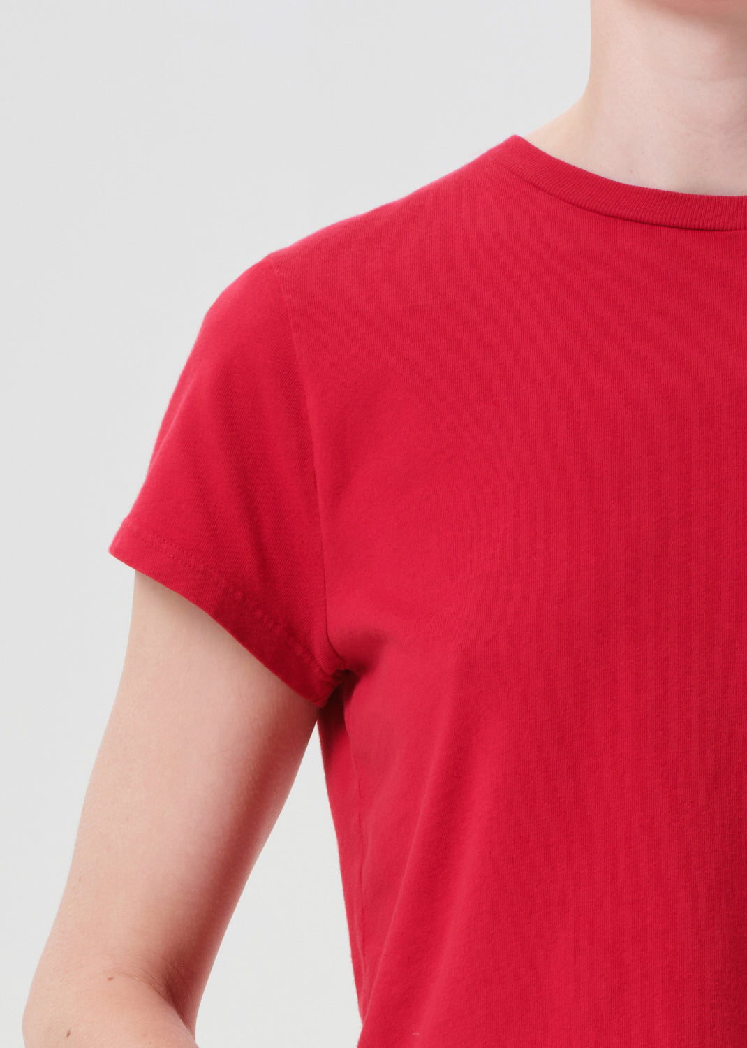 Red t-shirt worn by a person on a plain background