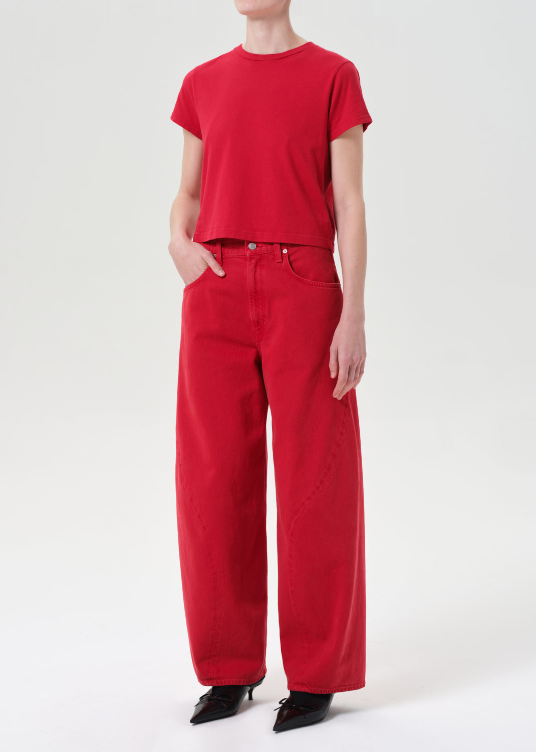 Person wearing a red outfit with a t-shirt and pants on a white background