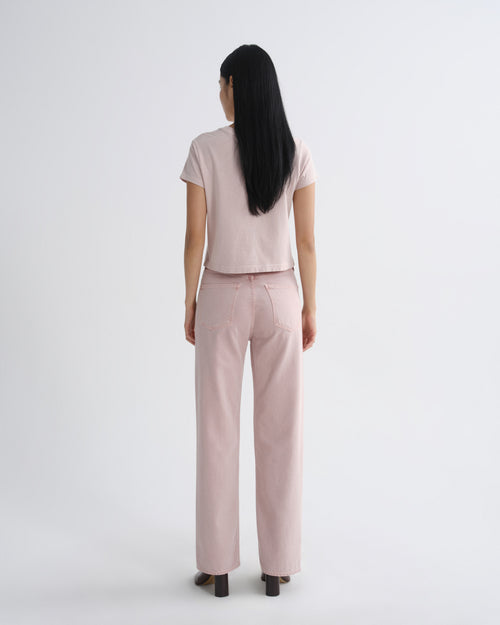 Person wearing a light pink outfit on a white background