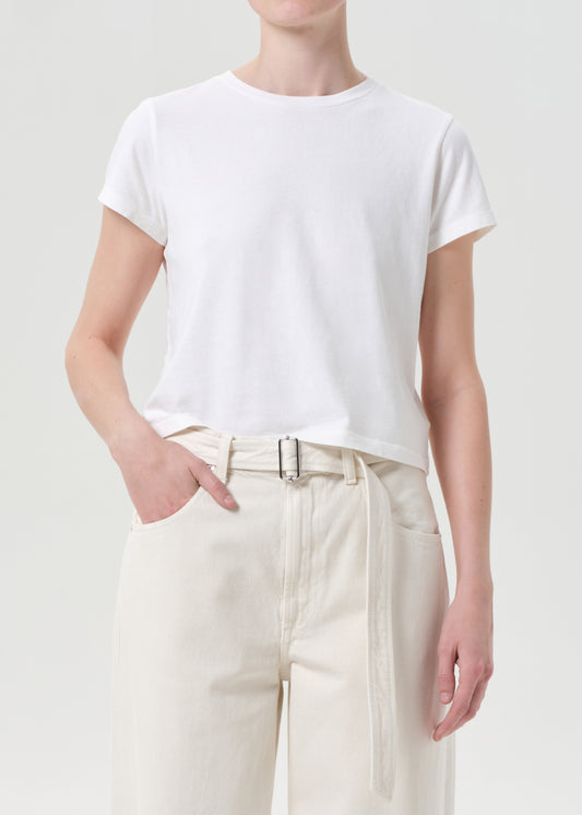 Person wearing a white t-shirt and beige pants on a plain background