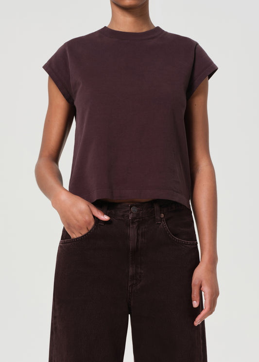 Person wearing a dark brown t-shirt and pants on a white background
