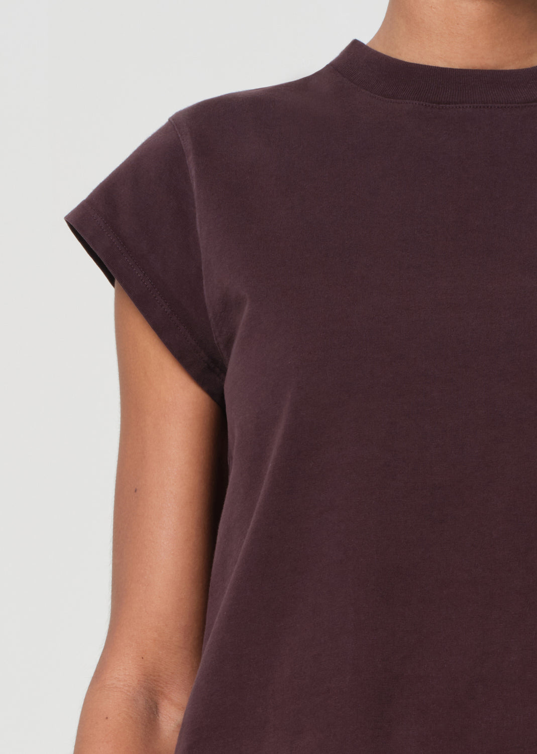 Brown t-shirt worn by a person on a light gray background
