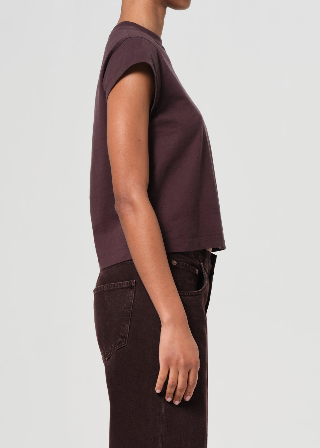Person wearing a maroon t-shirt and pants on a light gray background