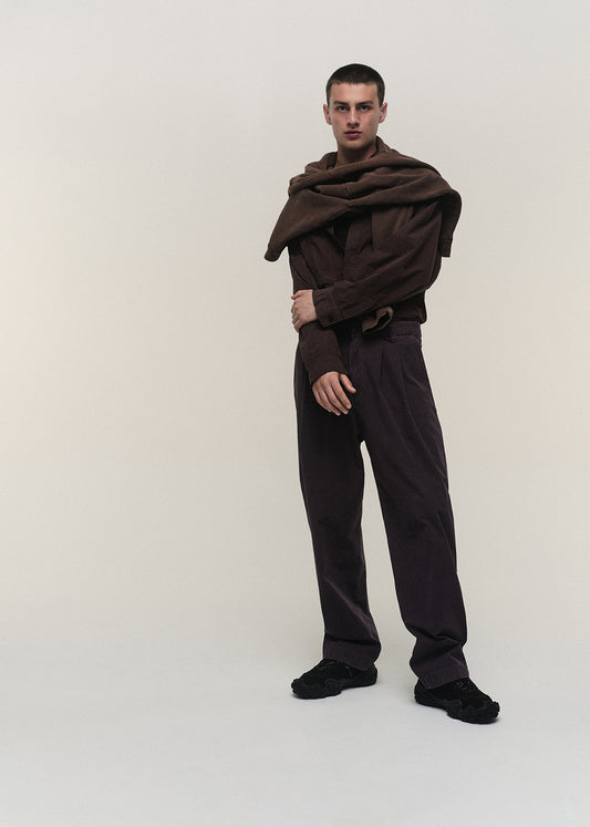 Person wearing a brown scarf and pants on a white background