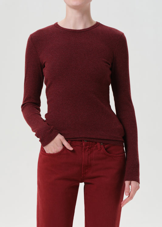 Person wearing a burgundy sweater and pants on a white background