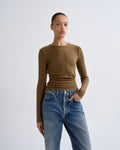 Person wearing a brown sweater and blue jeans on a white background