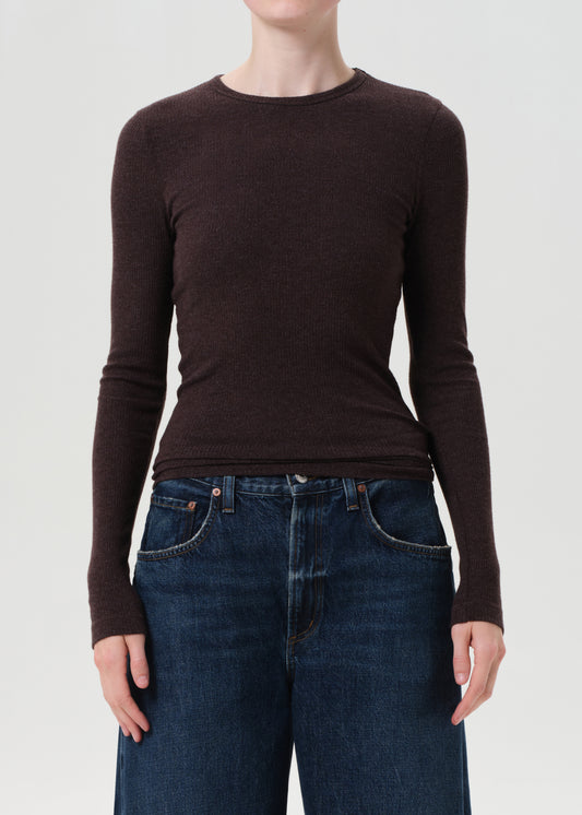 Person wearing a brown long-sleeve shirt and blue jeans on a white background