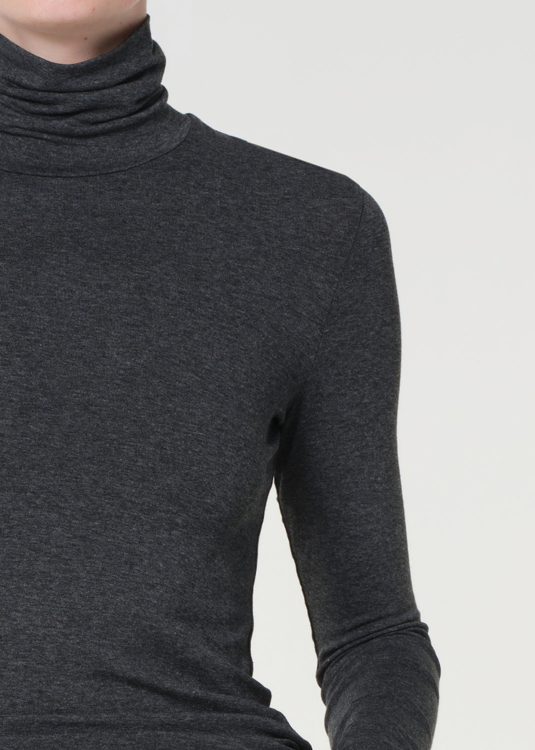 Dark gray turtleneck sweater on a plain background