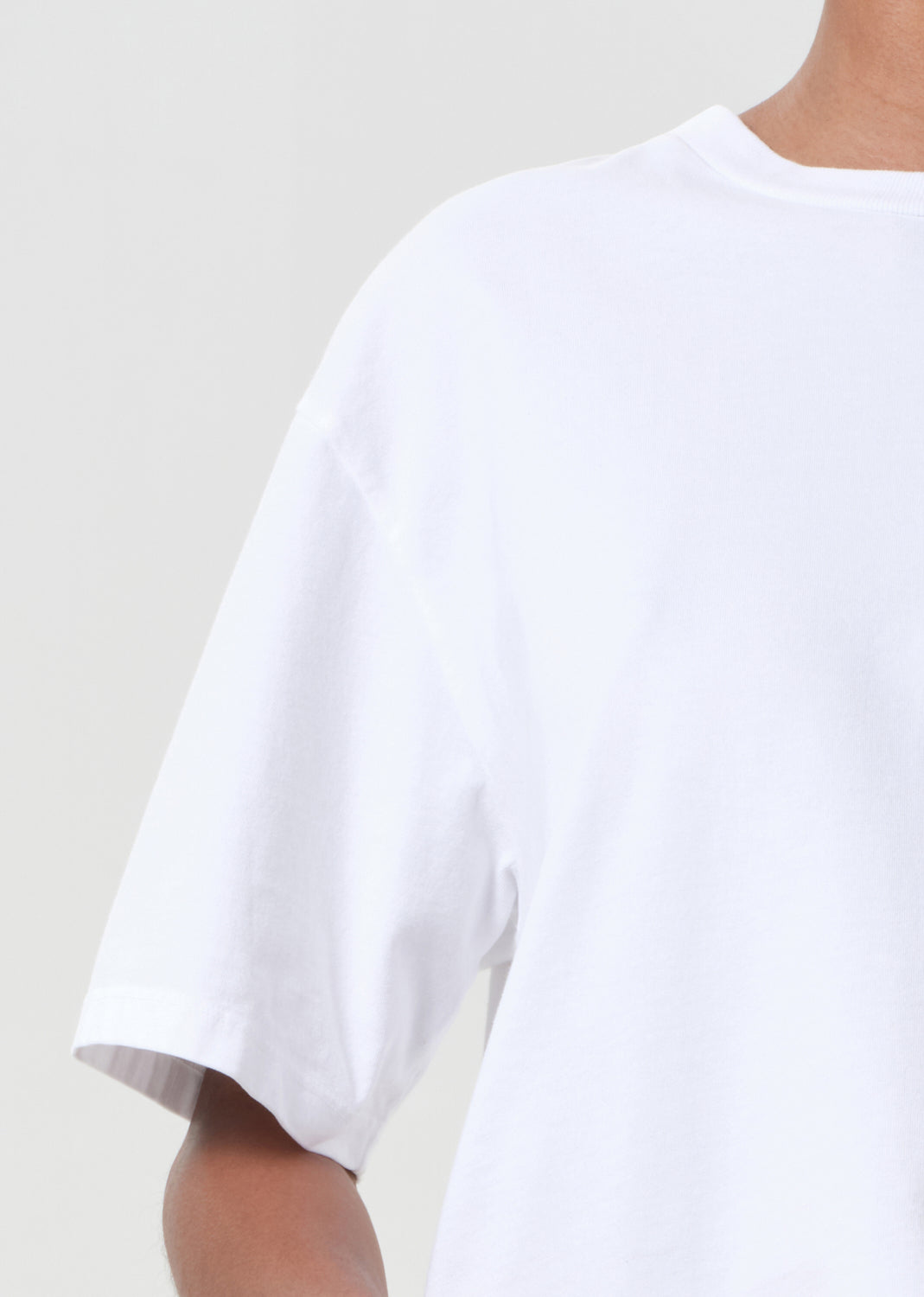 White t-shirt worn by a person on a plain background