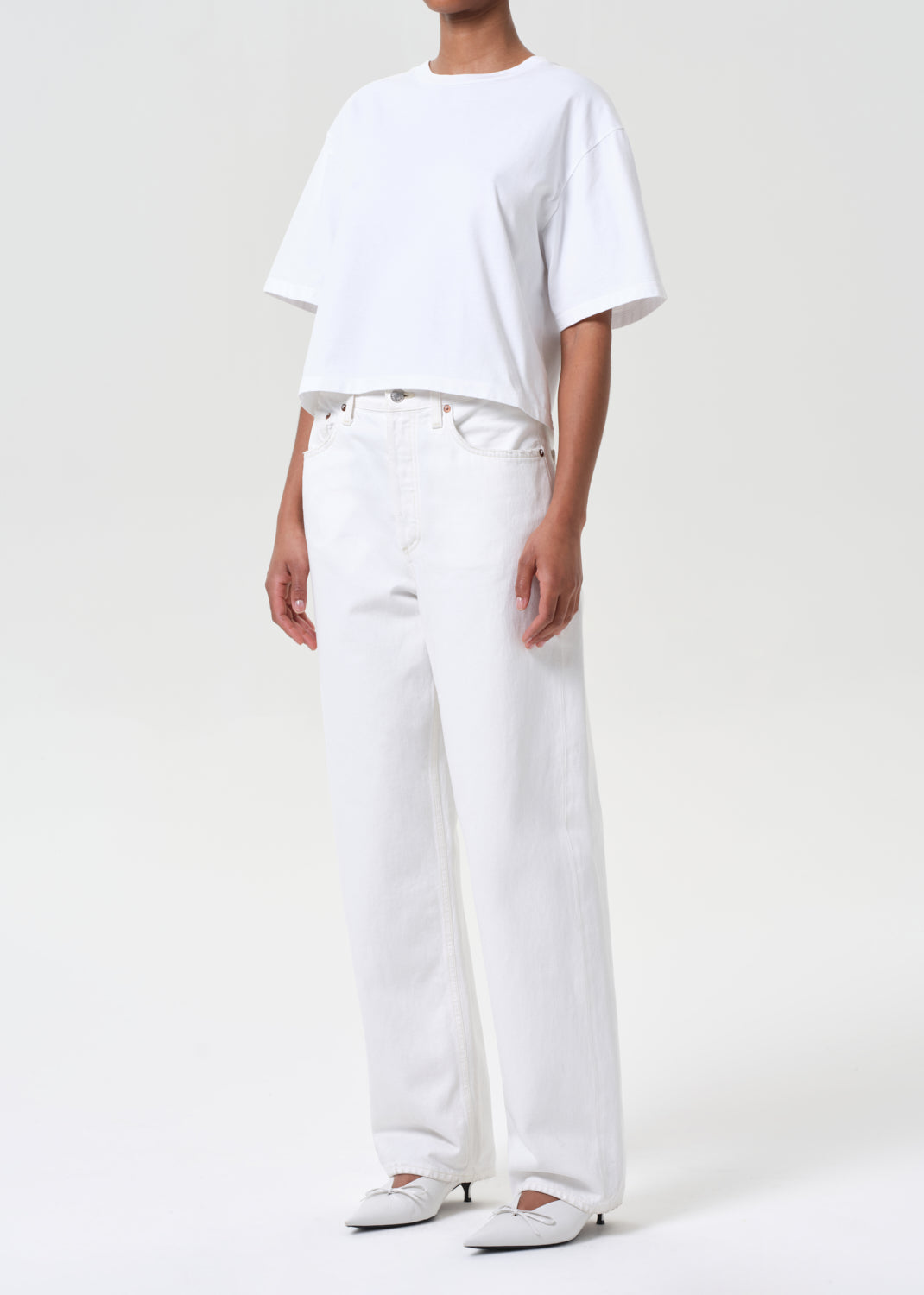Person wearing a white t-shirt and pants on a plain background