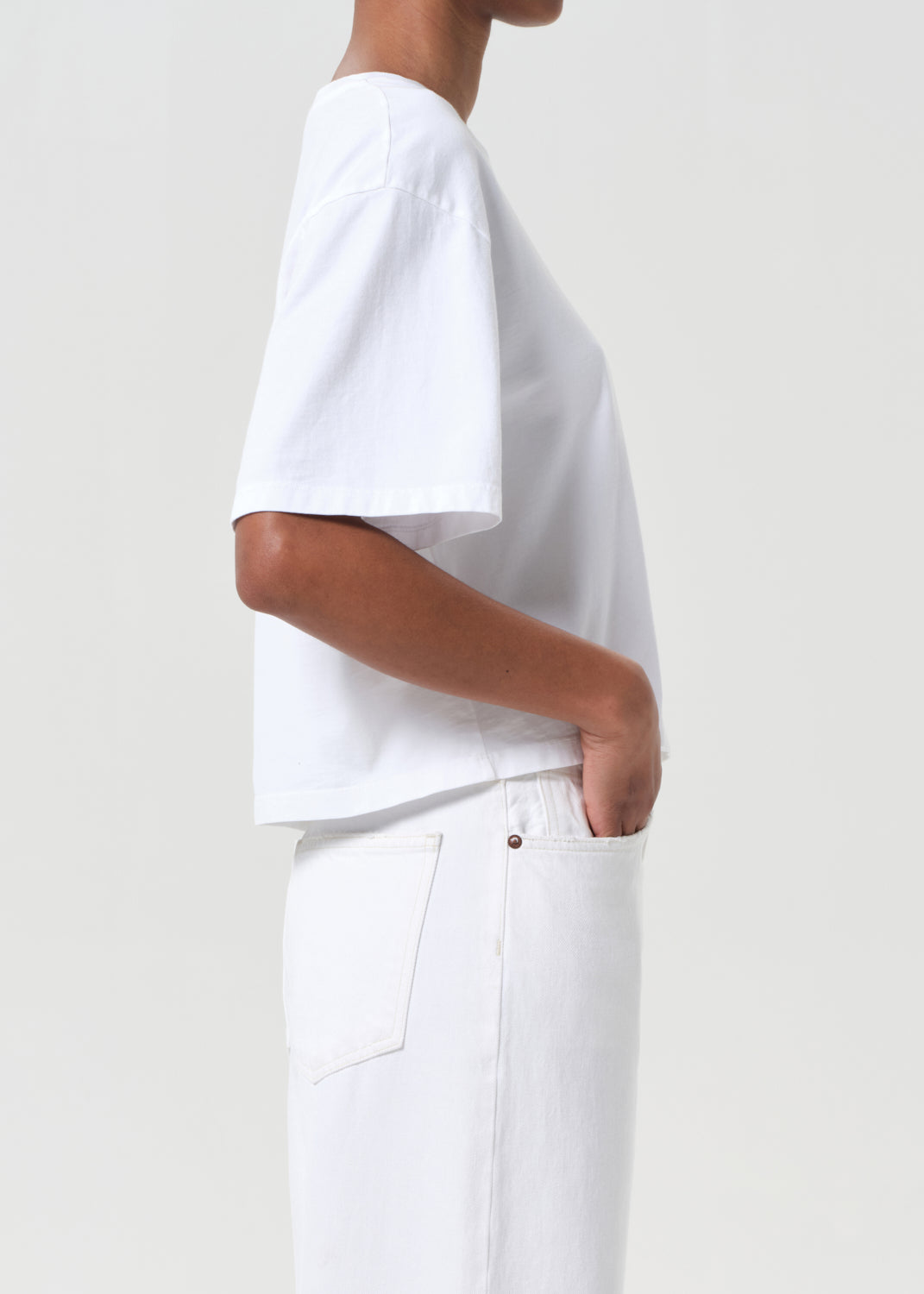 Person wearing a white t-shirt and pants on a plain background