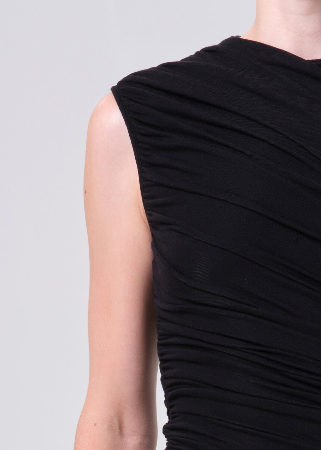 Black sleeveless dress with draped design on a plain background