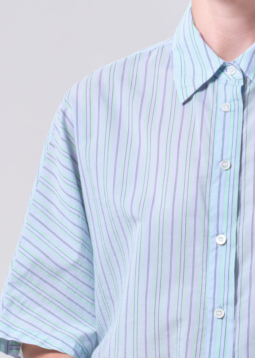 Light blue striped shirt worn by a person on a plain background