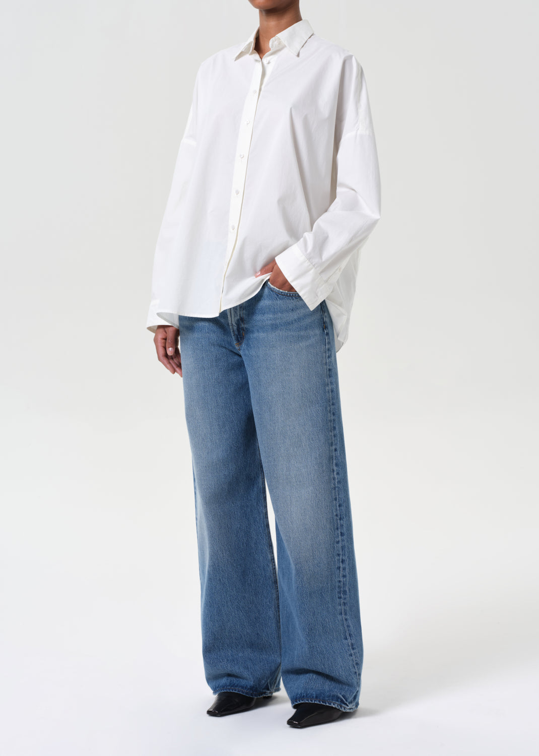 Person wearing a white shirt and blue jeans on a white background