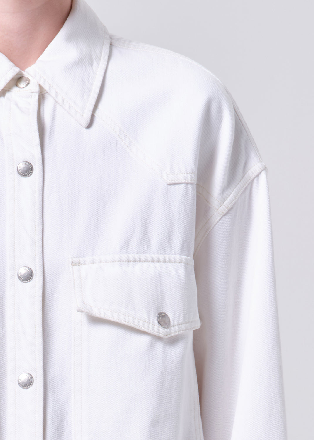 Close-up of a white button-up shirt with a plain background