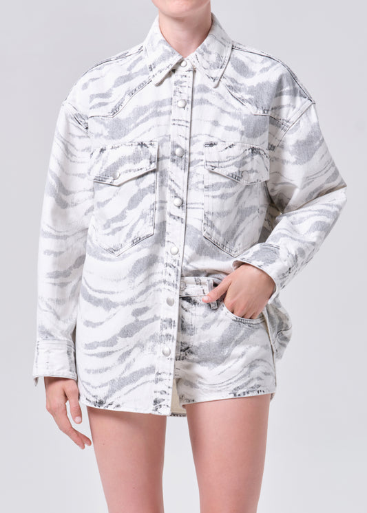 Person wearing a white camouflage shirt and shorts on a gray background