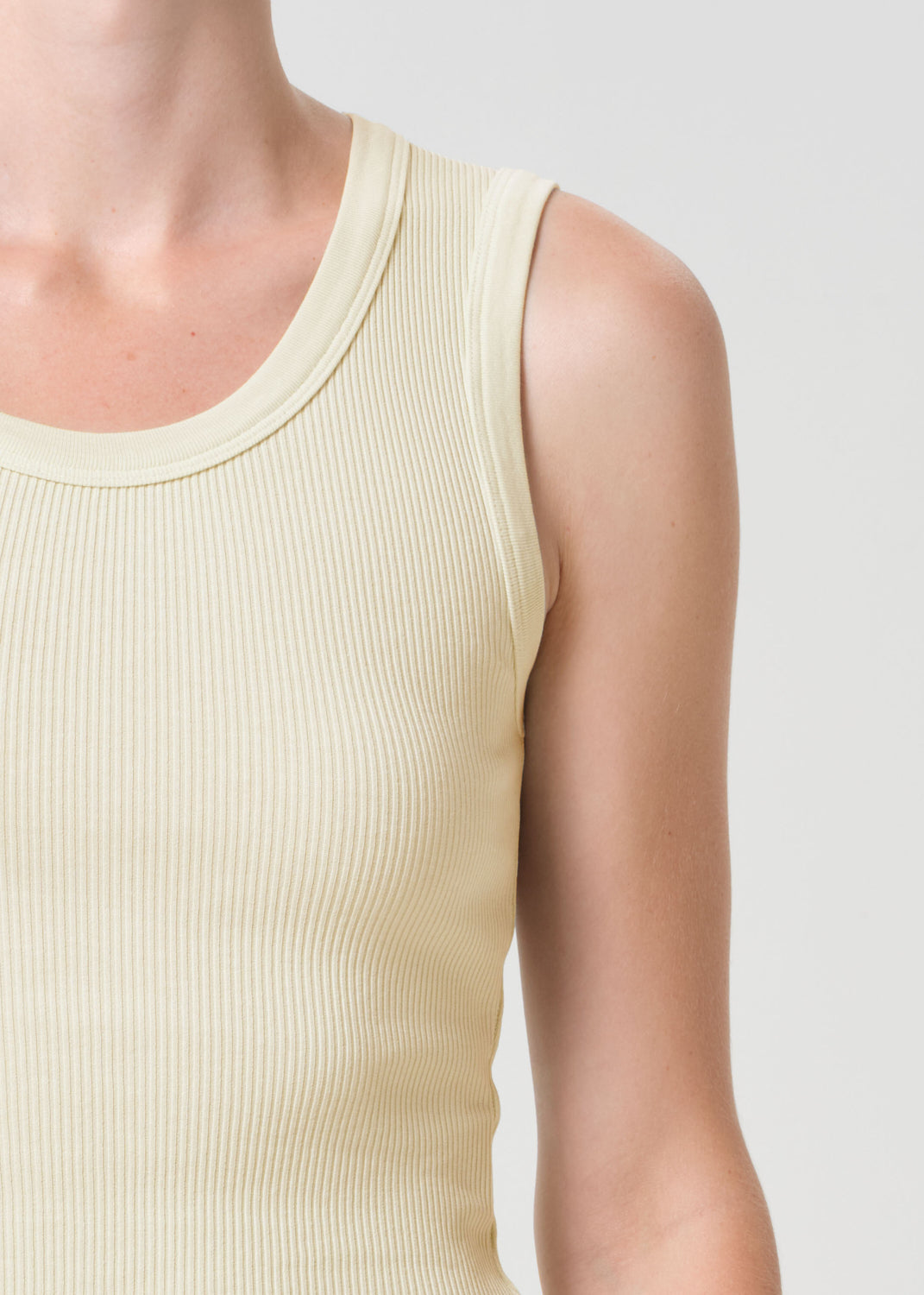 Beige ribbed tank top worn by a person on a plain background
