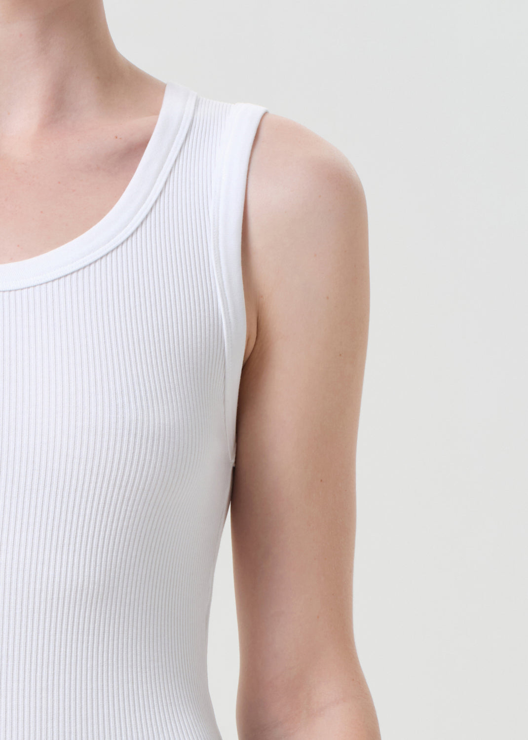 White sleeveless top worn by a person on a light gray background