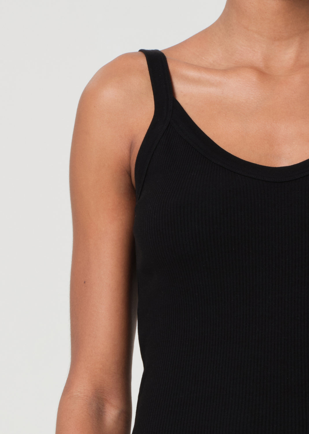 Black tank top worn by a person on a plain background