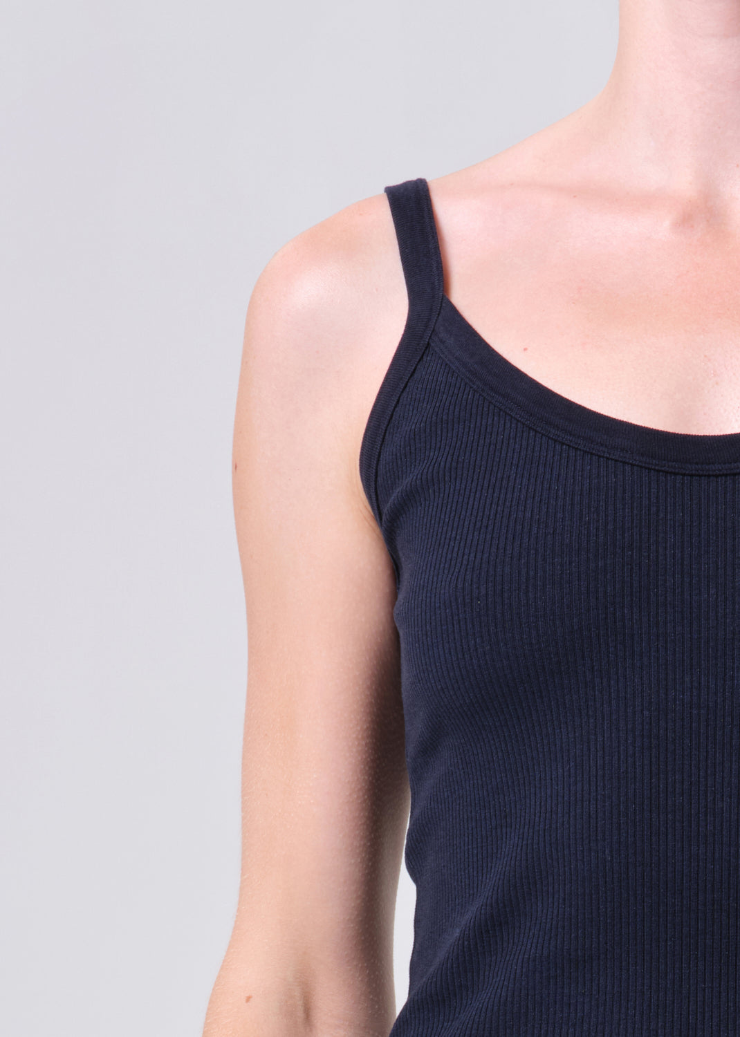 Navy blue tank top worn by a person on a light gray background