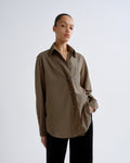 Woman wearing a brown and yellow striped shirt on a white background