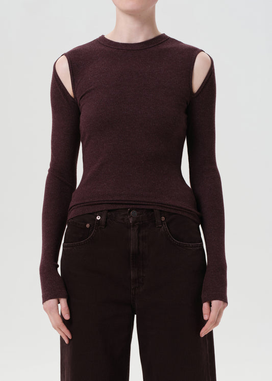 Person wearing a brown long-sleeve top with cut-out shoulders on a white background