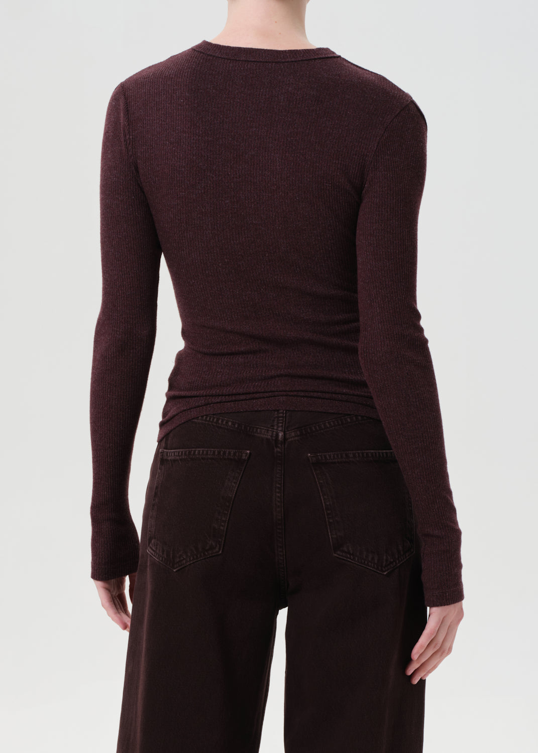 Brown long-sleeve top and dark pants on a white background