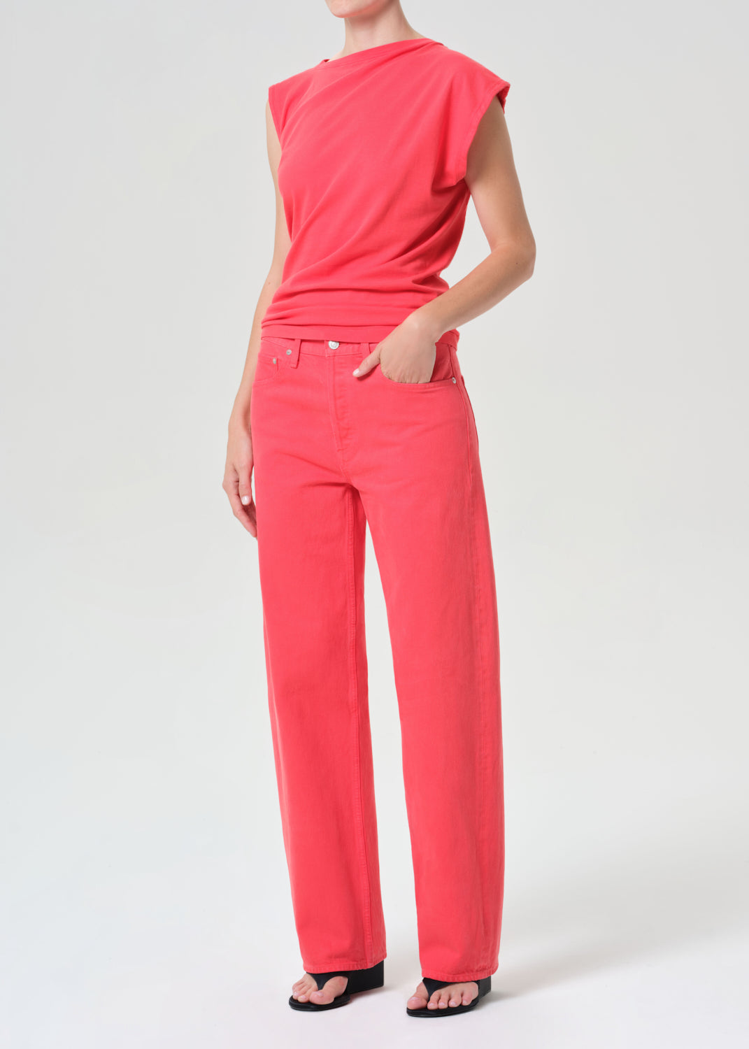 Person wearing a bright pink outfit on a white background