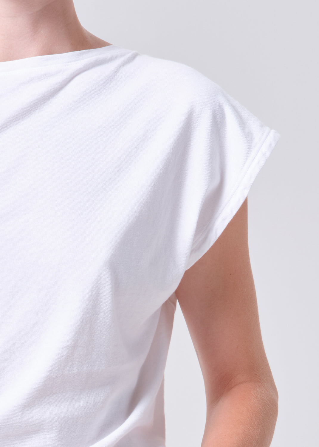 White dress with a draped neckline on a plain background