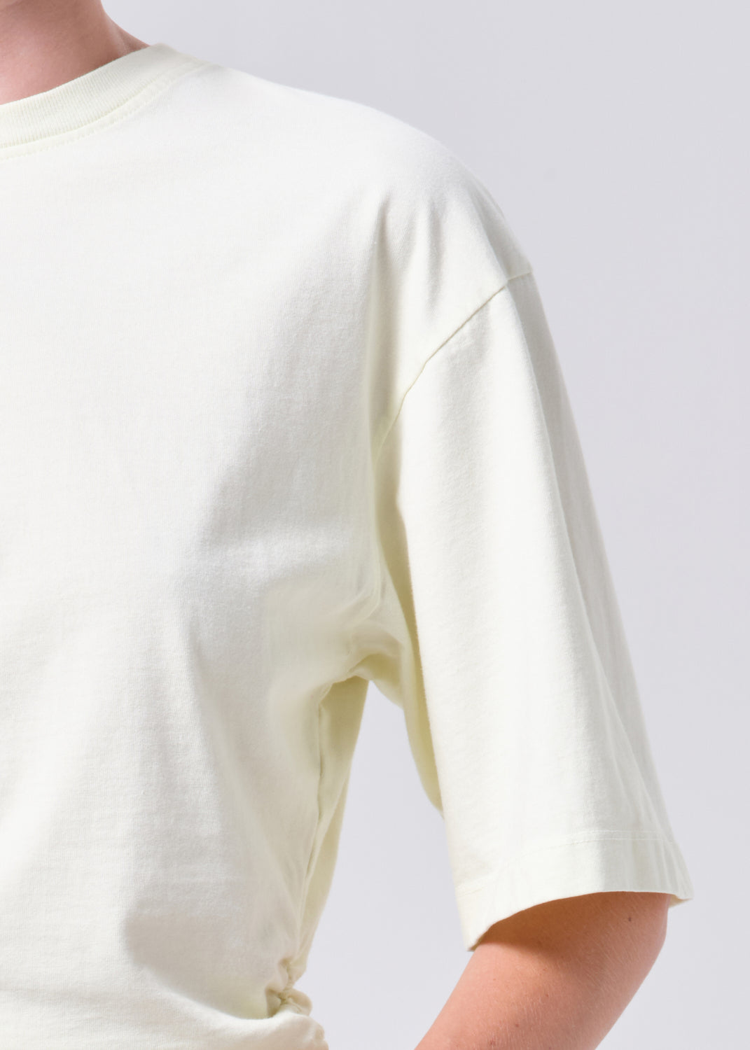 White t-shirt worn by a person on a white background