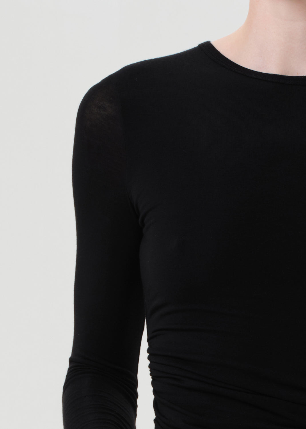 Black long-sleeve top on a plain background