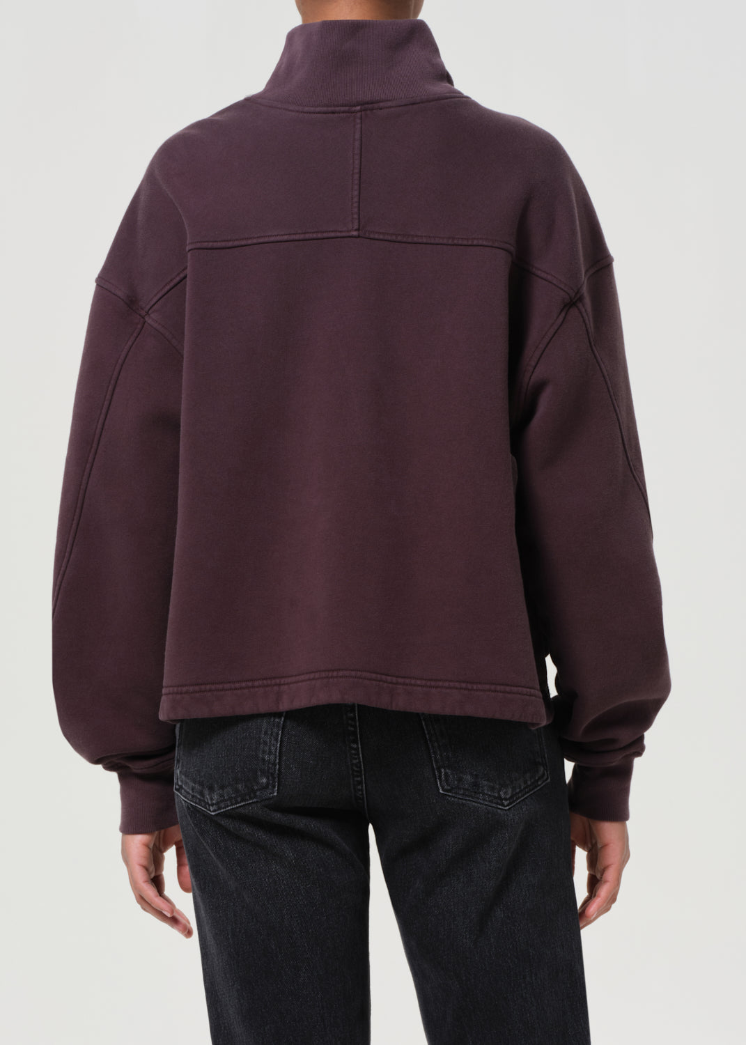 Person wearing a dark purple jacket on a white background