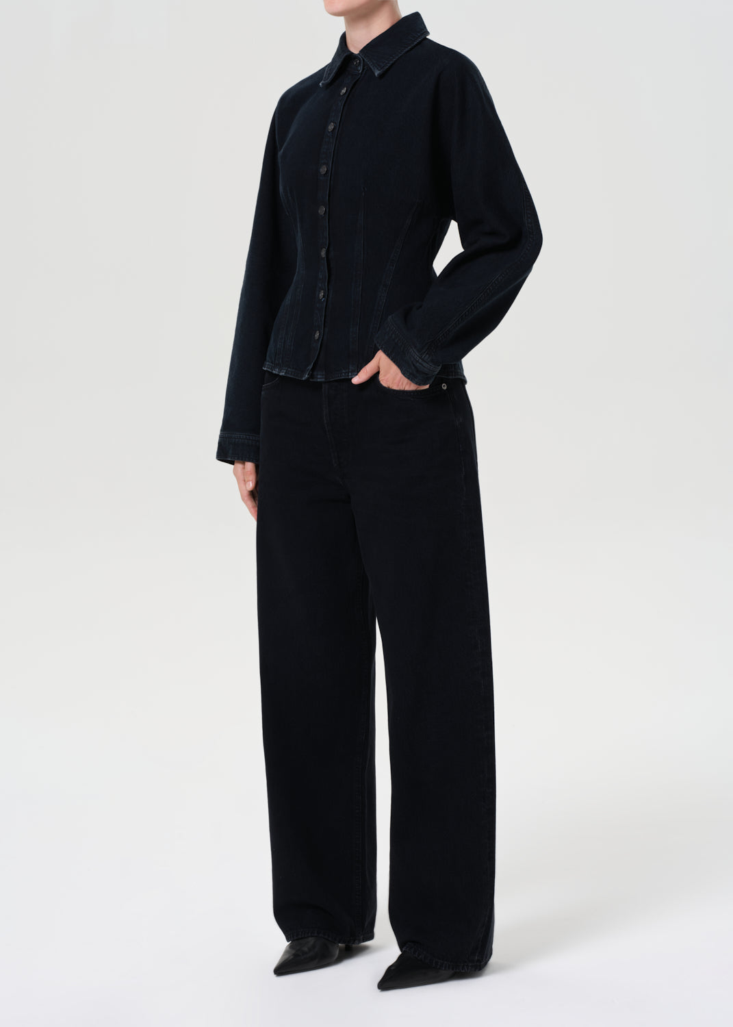 Person wearing a black shirt and black pants on a white background