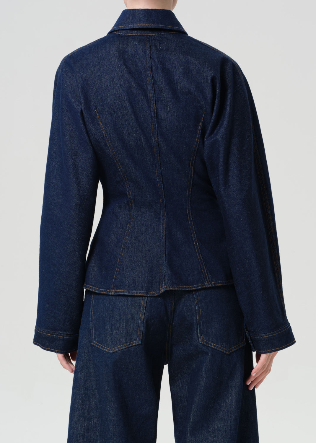 Dark denim jacket and pants on a plain background