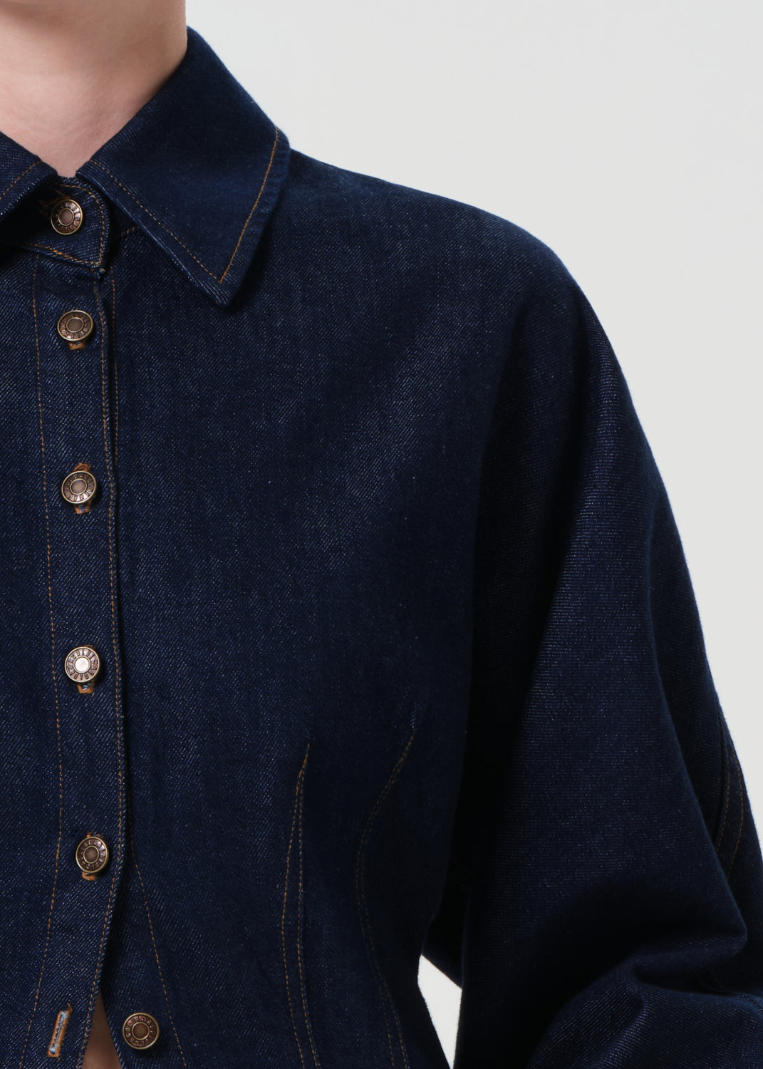 Navy blue denim jacket with button details on a plain background